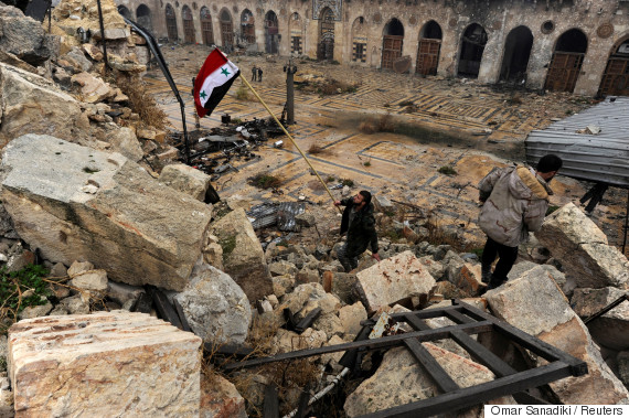 A member of forces loyal to Syria's President Bashar al-Assad attempts to erect the Syrian national flag inside the Umayyad mosque, in the government-controlled area of Aleppo, during a media tour, Syria December 13, 2016. REUTERS/Omar Sanadiki     TPX IMAGES OF THE DAY